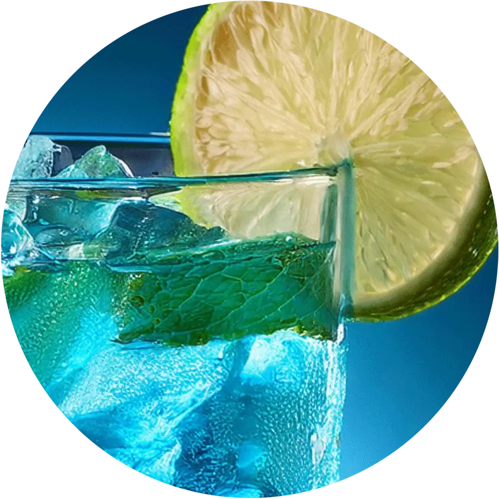 Ein Glas mit eiskaltem blauen Getränk, verziert mit einer Limettenscheibe und Minzblättern.