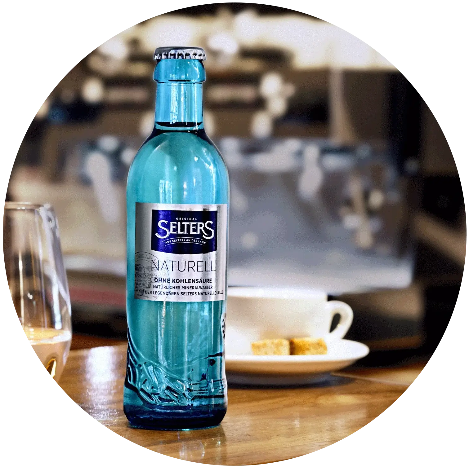 Eine blaue Mineralwasserflasche steht auf einem Tisch in einem Café.