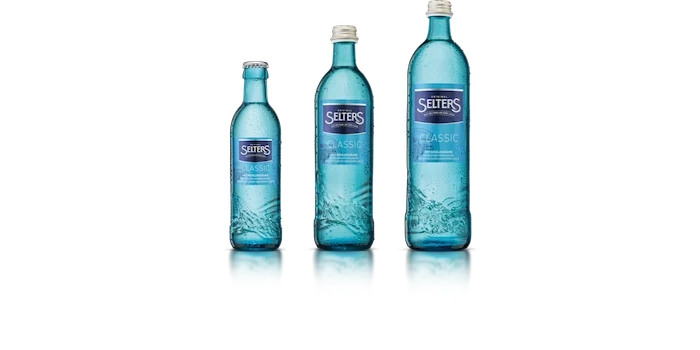 Vier blaue Wasserglasflaschen stehen nebeneinander mit unterschiedlichen Bezeichnungen.