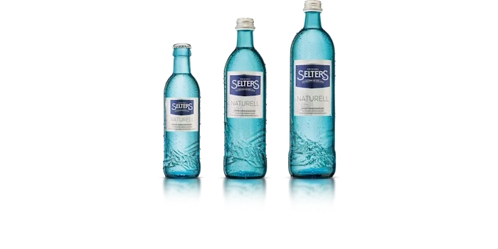 Vier gefüllte blaue Wasserflaschen in verschiedenen Größen stehen nebeneinander.